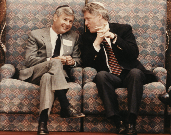 Bill Clinton whispers something to Bob Graham as he smiles and they sit wearing kippot in Temple Beth Israel, Sunrise, Florida, 1992